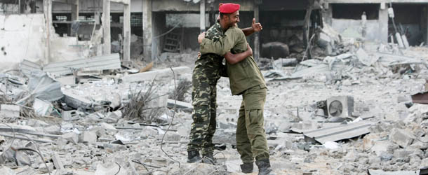 Hamas police officers embrace after their return to their destroyed Al-Saraya headquarters in Gaza City November 22, 2012, a day after a cease fire was declared between Israel and Hamas. An Egypt-brokered truce took hold in the Gaza Strip after a week of bitter fighting between militant groups and Israel, with both sides claiming victory but remaining wary. AFP PHOTO/MAHMUD HAMS (Photo credit should read MAHMUD HAMS/AFP/Getty Images)
