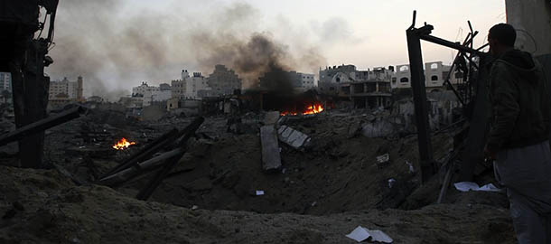 A Palestinian man looks at the destruction after Israeli air strikes in Gaza City on November 19, 2012. Israeli air strikes on Sunday killed 31 Palestinians in the bloodiest day so far of its air campaign on the Gaza Strip, as diplomatic efforts to broker a truce intensified. AFP PHOTO/MOHAMMED ABED (Photo credit should read MOHAMMED ABED/AFP/Getty Images)
