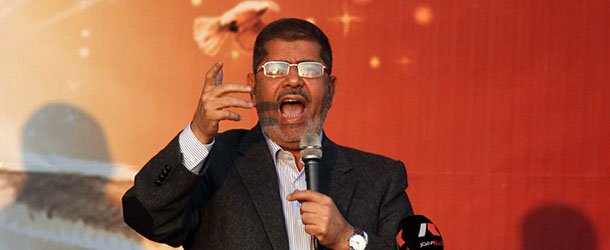 Egypt&#8217;s Islamist President Mohamed Morsi addresses his supporters in front of the presidential palace in Cairo on November 23, 2012. Thousands of ecstatic supporters of Morsi gathered outside the presidential palace to defend their leader against accusations from rival protesters that he has become a dictator. AFP PHOTO/STR (Photo credit should read -/AFP/Getty Images)
