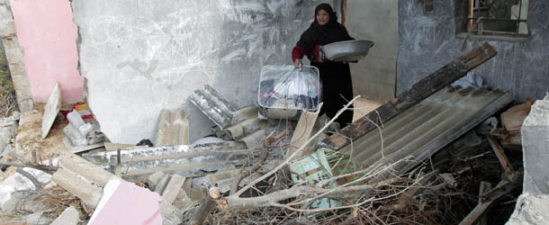 A Palestinian woman collects items from her destroyed home following an Israeli military air strike in Rafah town in the southern Gaza Strip, on November 11, 2012. The flare-up which began November 10, was one of the most serious since Israel&#8217;s devastating 22-day operation in the Gaza Strip over New Year 2009, has culminated in six Palestinians being killed and 32 injured by Israeli strikes after militants fired on an Israeli jeep, wounding four soldiers, medics and witnesses said. AFP PHOTO/ SAID KHATIB (Photo credit should read SAID KHATIB/AFP/Getty Images)
