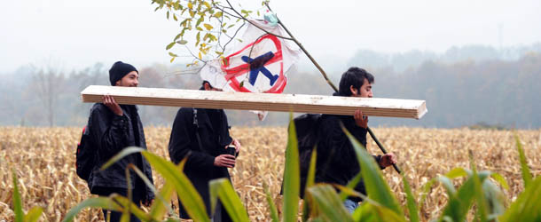 Farmers, environmental activists and opponents carry planks as they rebuild the houses that they squatted to protest against a project to build an international airport on November 17, 2012 in Notre-Dame-des-Landes, western France. The project was signed in 2010 and the international airport is supposed to open in 2017 near the city of Nantes. AFP PHOTO/JEAN-FRANCOIS MONIER. (Photo credit should read JEAN-FRANCOIS MONIER/AFP/Getty Images)
