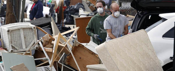People throw away furniture, and other ruined items in Seaside Heights, N.J., Monday, Nov. 12, 2012, after residents of Seaside Heights were allowed back in their homes for a few hours Monday, two weeks after the region was pounded by Superstorm Sandy. (AP Photo/Mel Evans)

