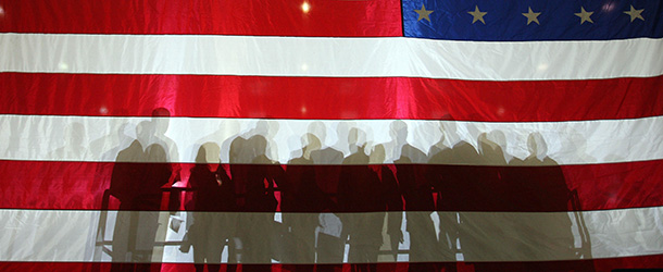 The shadows of supporters fall on the flag during a rally for presidential hopeful Arizona Senator John McCain at Orlando International Airport 28 January, 2008 in Orlando, Florida. Senator John McCain and former Massachusetts governor Mitt Romney stepped up their mutual attacks on the eve of Tuesday&#8217;s key Republican presidential primary that will pit the two in fierce battle. AFP PHOTO/DON EMMERT (Photo credit should read DON EMMERT/AFP/Getty Images)
