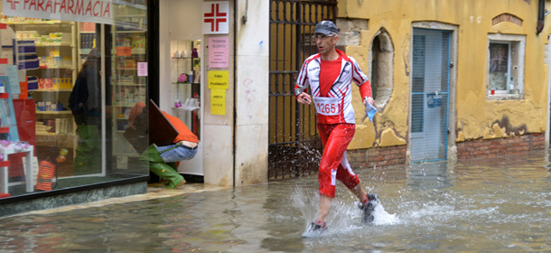 A man runs in a flooded street during a &#8216;acqua alta&#8217; on November 11, 2012 in Venice. Rain and wind hit the north of Italy on Sunday and the folooding reached 150 centimetres in Venice. AFP PHOTO / MARCO SABADIN (Photo credit should read Marco Sabadin,Marco Sabadin/AFP/Getty Images)
