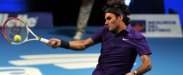 Swiss tennis player Roger Federer hits a return during an exhibition match with French tennis player Jo-Wilfried Tsonga at El Campin Coliseum in Bogota, Colombia, on December 15, 2012. AFP PHOTO/Guillermo Legaria (Photo credit should read GUILLERMO LEGARIA/AFP/Getty Images)
