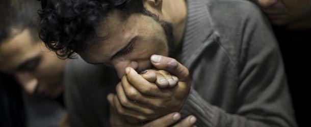 FOR USE AS DESIRED, YEAR END PHOTOS &#8211; FILE &#8211; In this Nov. 18, 2012 file photo, a Palestinian man kisses the hand of a dead relative in the morgue of Shifa Hospital in Gaza City. (AP Photo/Bernat Armangue, File)
