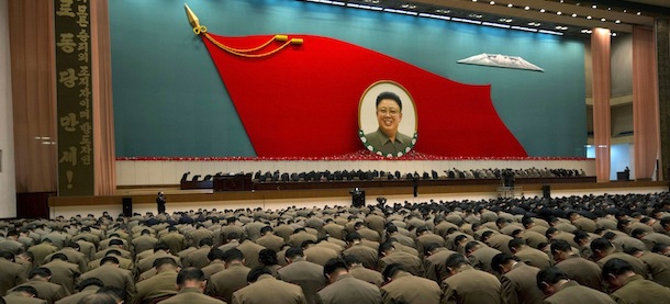 North Korean military officers bow at an image of late North Korean leader Kim Jong Il during a national meeting of top party and military officials on the eve of Kim&#8217;s first death anniversary in Pyongyang, North Korea, Sunday, Dec. 16, 2012. Large characters on vertical banner at left reads &#8220;Hurrah to the Workers&#8217; Party of Korea&#8221;. (AP Photo/Ng Han Guan)
