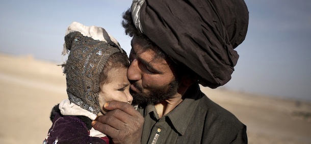 In this Oct. 20, 2012 photo, an Afghan nomad kisses his young daughter while watching his herd in Marjah, Helmand province, Afghanistan. In southern Helmand province, one of AfghanistanÃ­s deadliest battlefields, angry residents say 11 years of war has brought them widespread insecurity. They say they are too afraid to go out after dark because of marauding bands of thieves and during the day corrupt police and government officials bully them into paying bribes. Development that was promised hasnÃ­t materialized and the TalibanÃ­s rule is often said to be preferred. (AP Photo/Anja Niedringhaus)
