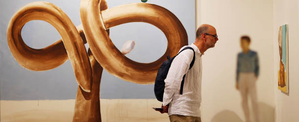 MIAMI BEACH, FL &#8211; DECEMBER 05: Santiago Caleya looks at the art in the Mai 36 gallery as Art Basel opens at the Miami Beach Convention Center on December 5, 2012 in Miami Beach, Florida. The 11th edition of the art show runs from December 6 through the 9th. (Photo by Joe Raedle/Getty Images)
