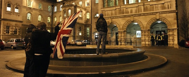 Loyalists hold the British flag inside the grounds of Belfast City Hall, Northern Ireland, Monday, Dec. 3, 2012.
Two security staff at the hall were also injured. Separately, trouble broke out on the Lower Newtownards Road in east Belfast. The trouble broke out after the council voted to fly the flag only on 15 designated days during the year. The decision marks a change to the current policy by which the flag is displayed outside the building 365 days a year, but the council&#8217;s decision has angered many loyalists. (AP Photo/Peter Morrison
