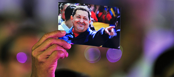 A woman holds a picture of Venezuelan President Hugo Chavez during the concert &#8220;Song, Life and Hope, celebrated in his honor, December 17, 2012 in Managua. Chavez is recovering in Cuba following a fourth operation for a recurrence of cancer. AFP PHOTO/Hector RETAMAL (Photo credit should read HECTOR RETAMAL/AFP/Getty Images)
