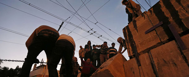 Protesters climb a wall during a demonstration in front of the presidential palace in Cairo, Egypt, Tuesday, Dec. 11, 2012. Thousands of opponents and supporters of Egypt&#8217;s Islamist president were flocking to key locations in the nation&#8217;s capital ahead of rival mass rallies Tuesday, four days before a nationwide referendum on a contentious draft constitution. (AP Photo/Petr David Josek)
