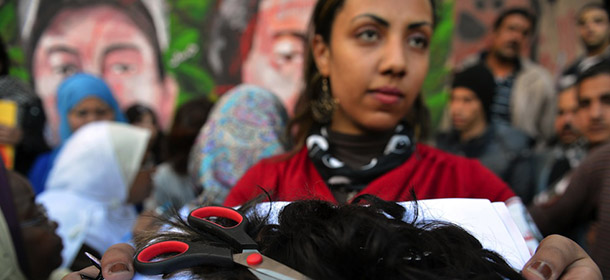 Egyptian Fatma al-Sharif,21, holds a bunch of hair cut from female protesters during a demonstration by Egytpian women against their country&#8217;s new constitution draft, on December 25, 2012 in Cairo?s Tahrir square. Egyptian opposition sees the new constitution as a wedge to usher in creeping Islamic law through a weakening of human rights, particularly women&#8217;s rights, and undermine the independence of the judiciary. Authorities in Egypt are to release official results a constitutional referendum which the opposition alleges was marred by fraud. AFP PHOTO / KHALED DESOUKI (Photo credit should read KHALED DESOUKI/AFP/Getty Images)
