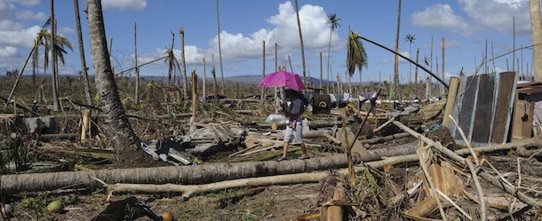 This picture taken on December 10, 2012 shows residents walking along a toppled coconut tree near Bagangga town in the aftermath of Typhoon Bopha. The United Nations launched a 65 million USD global appeal on December 10 to help desperate survivors of a typhoon that killed more than 600 people and affected millions in the southern Philippines. AFP PHOTO / TED ALJIBE (Photo credit should read TED ALJIBE/AFP/Getty Images)
