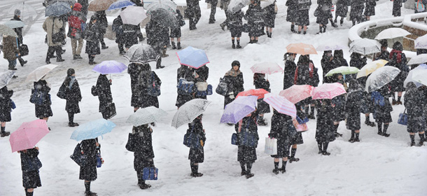Students make lines on a bus terminal covered by snow to wait for transportation in Nagano City in the morning on December 10, 2012. Heavy snow hit wide areas of Japan on December 10 due to cold air that brought a winter pressure system. AFP PHOTO / KAZUHIRO NOGI (Photo credit should read KAZUHIRO NOGI/AFP/Getty Images)
