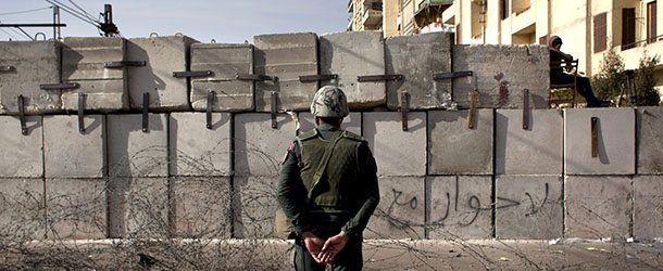 An Egyptian soldier stands guard in front of the presidential palace in Cairo, Egypt, Sunday, Dec. 9, 2012. Egypt&#8217;s liberal opposition has called for more protests on Sunday after the president made concessions overnight that fell short of their demands to rescind a draft constitution going to a referendum on Dec. 15. (AP Photo/Nasser Nasser)
