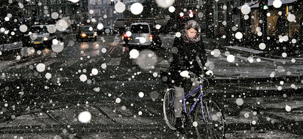 A woman rides a bike on her way to work in heavy snow in the Center of Copenhagen, Denmark, Wednesday morning Dec. 5, 2012, after the temperature throughout the night ranged between 10 and 12 degrees below zero. The classic winter weather continues with frost and snow, according to meteorologists. (AP Photo/Polfoto/Joachim Adrian) DENMARK OUT
