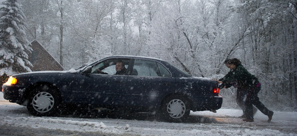 Two men push a car on a slick road as snow falls October 29, 2011 in Putney, Vermont. Freezing conditions prevailed on the US East Coast Sunday after a rare October snowstorm and icy rain reportedly killed at least three people, sparked long airport delays and caused massive power outages. The &#8220;historic early season&#8221; snowstorm wrought havoc on air, rail and road traffic from Washington to Boston, with the National Weather Service warning that travel at night would be &#8220;extremely hazardous.&#8221; AFP PHOTO/DON EMMERT (Photo credit should read DON EMMERT/AFP/Getty Images)
