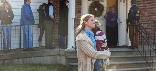 NEWTOWN, CT &#8211; DECEMBER 14: A woman holds a child as people line up to enter the Newtown Methodist Church near the the scene of an elementary school shooting on December 14, 2012 in Newtown, Connecticut. According to reports, there are about 27 dead, 18 children, after a gunman opened fire in at the Sandy Hook Elementary School. The shooter was also killed. (Photo by Douglas Healey/Getty Images)

