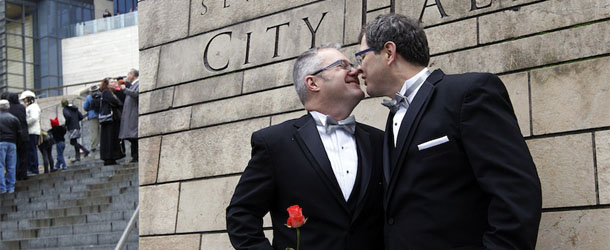 Terry Gilbert, left, kisses his husband Paul Beppler after wedding at Seattle City Hall, becoming among the first gay couples to legally wed in the state, Sunday, Dec. 9, 2012, in Seattle. Gov. Chris Gregoire signed a voter-approved law legalizing gay marriage Dec. 5 and weddings for gay and lesbian couples began in Washington on Sunday, following the three-day waiting period after marriage licenses were issued earlier in the week. (AP Photo/Elaine Thompson)
