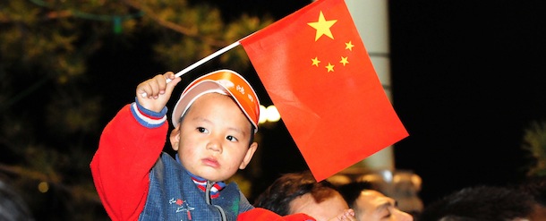 This picture taken on October 1, 2012 shows a young boy waving a national flag during a flag raising ceremony on China's National Day at Tiananmen Square in Beijing. China marked the 63rd anniversary of the founding of the People's Republic of China on October 1. CHINA OUT AFP PHOTO (Photo credit should read AFP/AFP/GettyImages)