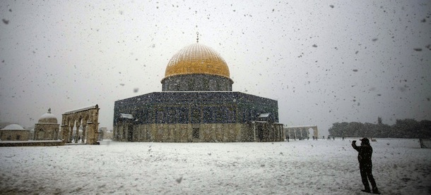A man takes pictures of the snow-covered Dome of the Rock at the Al-Aqsa mosque compound in the old city of Jerusalem on January 10, 2013. Jerusalem was transformed into a winter wonderland after heavy overnight snowfall turned the Holy City and much of the region white, bringing hordes of excited children onto the streets. AFP PHOTO/AHMAD GHARABLI (Photo credit should read AHMAD GHARABLI/AFP/Getty Images)