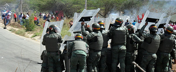 Members of the National Guard take shelter before a riot in front of the prison Uribana, in Barquisimeto, Lara state, Venezuela, on January 25, 2013. At least 50 people were killed and 90 others wounded in Friday clashes at a prison in northwest Venezuela, a hospital director who was at the scene said. AFP PHOTO/Dedwinson Alvarez-Diario el Impulso (Photo credit should read -/AFP/Getty Images)