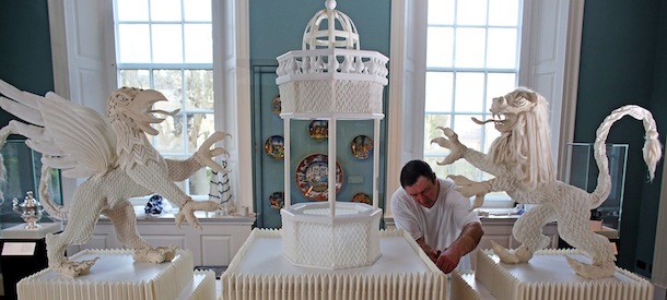 BATH, ENGLAND - JANUARY 31: Frohmut Zscheckel helps put the finishing touches to artist Joan Sallas' 1.5-metre-high folded linen table fountain he is displaying as part of a new exhibition 'Folded Beauty: Masterpieces in Linen', which is opening at the Holbourne Museum on January 31, 2013 in Bath, England. The exhibition of the lost art of linen folding, examples of which would once have graced the dining tables of Kings and Emperors in seventeenth century Europe, will include animals, flowers and even miniature buildings and fountains all made from intricately starched and folded linen. This is the first UK exhibition by the world's leading authority on historic linen folding who has previously exhibited his work across Europe and the USA. (Photo by Matt Cardy/Getty Images)