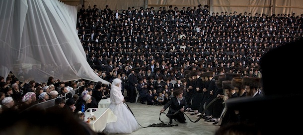 Miryam Teitelbaum, granddaughter of the Ultra-Orthodox Satmar Rebbe of Williamsburg, Rabbi Zalman Leib Teitelbaum, fulfills the Mitzvah tantz during her traditional Jewish wedding in the Israeli town of Beit Shemesh, near Jerusalem, Israel, early Thursday, Jan. 24, 2013. The bride enters to the men's section to fulfill the Mitzvah tantz, in which family members and honored rabbis are invited to dance in front of the bride, often holding a gartel, and then dancing with the groom. (AP Photo/Oded Balilty)