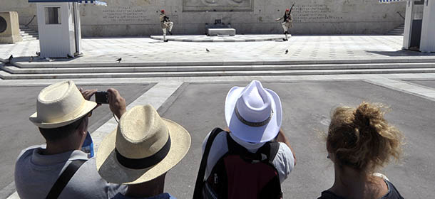 Tourists watch the presidental guards at the monument of the Unknown Soldier in front of the Greek Parliament in Athens on August 20, 2012. A Greek exit from the eurozone would be "manageable" even if it would be expensive and result in higher unemployment, a top member of the European Central Bank was quoted as saying on August 20. AFP PHOTO / LOUISA GOULIAMAKI (Photo credit should read LOUISA GOULIAMAKI/AFP/GettyImages)