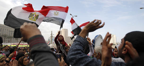 Egyptian demonstrator wave the national flag and shout slogans during a protest in Tahrir Square on January 25, 2013. Huge crowds are expected to demonstrate in Egypt on the second anniversary of the revolution that ousted Hosni Mubarak and brought in an Islamist government, as political tensions simmer and economic woes bite. AFP PHOTO/MOHAMMED ABED (Photo credit should read MOHAMMED ABED/AFP/Getty Images)