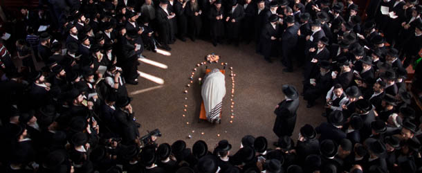 BNEI BRAK, ISRAEL - JANUARY 01: Ultra Orthodox Jewish men pray next to the body of Rabbi Abraham Jacob Friedman of Sadigura Hasidic dynasty during his funeral on January 01, 2013. in Bnei Brak, Israel. The Rabbi was the leader of the Sadigura Hasidic dynasty in Bnei Brak and died at the age of 84. (Photo by Uriel Sinai/Getty Images)