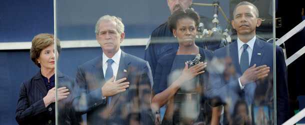 US President Barack Obama (R), his wife Michelle Obama (2nd R), Former US President George W. Bush (2nd L) and his wife Laura Bush (L) salute as the national anthem is played during the 10th Anniversary commemoration of the September 11, 2001 attacks at the lower Manhattan site of the World Trade Center September 11, 2011 in New York. Families of victims are reflected in the bullet proof glass. AFP PHOTO/Stan HONDA (Photo credit should read STAN HONDA/AFP/Getty Images)