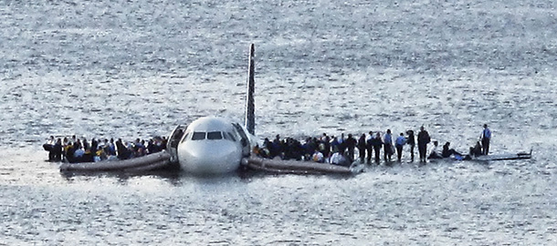 In this Thursday Jan. 15, 2009 file photo, airline passengers wait to be rescued on the wings of a US Airways Airbus 320 jetliner that safely ditched in the frigid waters of the Hudson River in New York, after a flock of birds knocked out both its engines. The audio recordings of US Airways Flight 1549, released Thursday, Feb 5, 2009 by the Federal Aviation Administration, reflect the initial tension between tower controllers and the cockpit and then confusion about whether the passenger jet went into the river. (AP Photo/Steven Day)