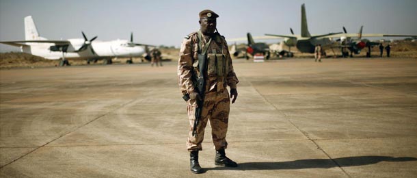 A Mali National Guard soldier stands guard on the military side of Bamako's airport Wednesday Jan. 16, 2013, during a joined visit to French and Malian troops by Mali's President Dioncounda Traore and French Ambassador to Mali Christian Rouyer. French troops pressed northward in Mali toward territory occupied by radical Islamists on Wednesday, military officials said, announcing the start of a land assault that will put soldiers in direct combat "within hours." (AP Photo/Jerome Delay)
