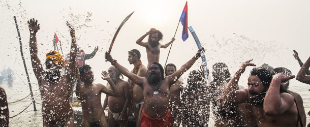 ALLAHABAD, INDIA - JANUARY 14: Naga sadhus run in to the waters of the holy Ganges river during the auspicious bathing day of Makar Sankranti of the Maha Kumbh Mela on January 14, 2013 in Allahabad, India. The Maha Kumbh Mela, believed to be the largest religious gathering on earth is held every 12 years on the banks of Sangam, the confluence of the holy rivers Ganga, Yamuna and the mythical Saraswati. The Kumbh Mela alternates between the cities of Nasik, Allahabad, Ujjain and Haridwar every three years. The Maha Kumbh Mela celebrated at the holy site of Sangam in Allahabad, is the largest and holiest, celebrated over 55 days, it is expected to attract over 100 million people. (Photo by Daniel Berehulak/Getty Images)