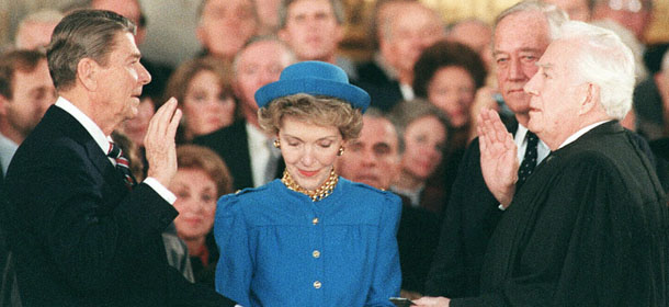 (FILES): This January 21, 1985 file photo shows then US President Ronald Reagan (L) being sworn in at the US Capitol for his second term of office by US Supreme Court Chief Justice Warren Burger (R) as First Lady Nancy Reagan (C) looks at the Bible. On January 20, 2009 history will made in the heart of the US capital when Barack Obama is sworn in as the nation's first black president witnessed by millions of jubilant supporters. Washington will be the proud host of the inauguration of the 44th president, marking the dawning of a new era ushered in by the wildly popular Obama and drawing the curtain on the controversial rein of George W. Bush. Initial estimates that up to five million people might descend on the sleepy city -- population normally around 600,000 -- have been revised downwards to between 1.5 million to two million visitors. AFP PHOTO / Files / Mike SARGENT (Photo credit should read MIKE SARGENT/AFP/Getty Images)