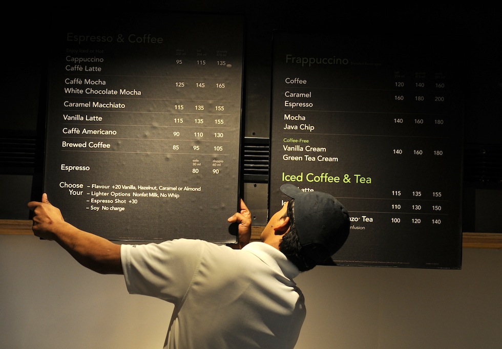 Un impiegato sistema i pannelli nel nuovo negozio di Starbucks a New Delhi, il primo in città. (SAJJAD HUSSAIN/AFP/Getty Images)