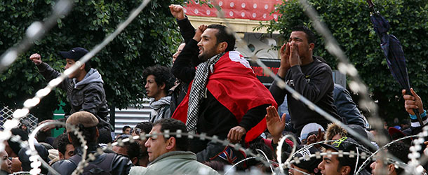 Tunisian protestors chant slogans behind barbed wire outside the Interior Ministry in Tunis, on February 7, 2013 during a demonstration against the killing of opposition figure and human rights lawyer Chokri Belaid. Police was deployed in force in the Tunisian capital amid fears the murder of the 48-year-old opposition figure could reignite nationwide violence, as the ruling Islamists broke ranks over how to defuse the crisis. AFP PHOTO / KHALIL (Photo credit should read KHALIL/AFP/Getty Images)