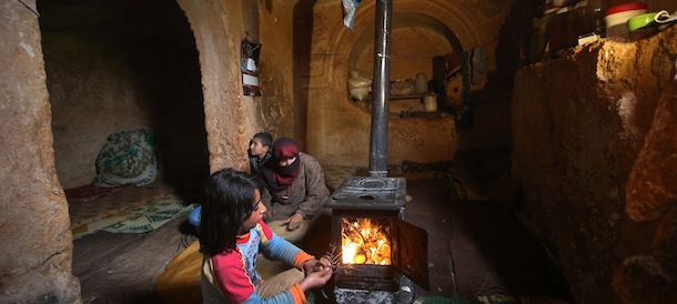 Nihal, 9, puts olive tree branches inside a wooden stove at an underground Roman tomb which they use shelter from Syrian government forces shelling and airstrikes, at Jabal al-Zaweya, in Idlib province, Syria, Thursday Feb. 28, 2013. Across northern Syria, rebels, soldiers, and civilians are making use of the country's wealth of ancient and medieval antiquities to protect themselves from Syria's two-year-old war. They are built of thick stone that has already withstood centuries, and are often located in strategic locations overlooking towns and roads. (AP Photo/Hussein Malla)