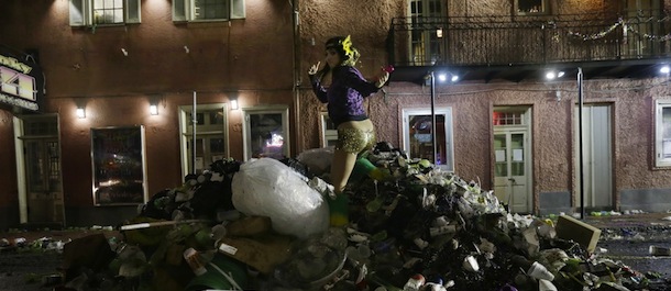 Melissa, no last name given, a VIP hostess and bartender at a Bourbon Street club, jumps on a pile of trash as she walk home with co-workers along Bourbon Street in the early morning of Ash Wednesday, the day after Mardi Gras, in the French Quarter of New Orleans, Wednesday, Feb. 13, 2013. The city begins to clean up after Mardi Gras comes to a close, with Ash Wednesday ushering in the solemn season of Lent. City and tourism officials are expected to talk about the impact of successive waves of tourists that hit town, first for Super Bowl and then a week later for Mardi Gras' final days. (AP Photo/Gerald Herbert)