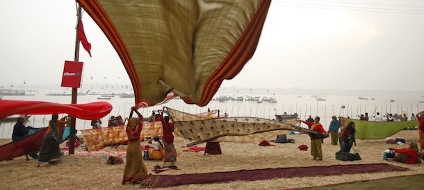 A group of Hindu devotees dry their clothes after a holy dip at Sangam, the confluence of the Ganges, Yamuna and mythical Saraswati River, during the Maha Kumbh Mela, in Allahabad, India, Friday, Jan. 18, 2013. Millions of Hindu pilgrims are expected to attend the Maha Kumbh festival, which is one of the world's largest religious gatherings that lasts 55 days and falls every 12 years. During the festival pilgrims bathe in the holy Ganges River in a ritual they believe can wash away their sins. (AP Photo/ Rajesh Kumar Singh)