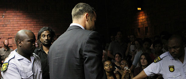 Olympic athlete Oscar Pistorius , center, is lead by police officer out of the witness bench after his bail application appearance at the magistrate court in Pretoria, South Africa, Friday, Feb. 15, 2013. Pistorius was taken into custody after a 30-year-old woman, Reeva Steenkamp, was shot dead at his home on Thursday, Feb. 14, 2013. (AP Photo/Themba Hadebe)