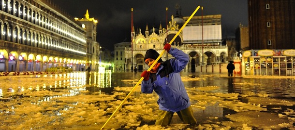 A woman wades through high water with floating ice in a flooded St. Mark's Square, in Venice, Italy, early Tuesday, Feb. 12, 2013. The phenomenon of high water, which floods the Venice lagoon, occurs mainly between autumn and spring when tides are reinforced by seasonal winds. The recent snow falls and low temperatures formed ice blocks in the water. (AP Photo/Luigi Costantini)