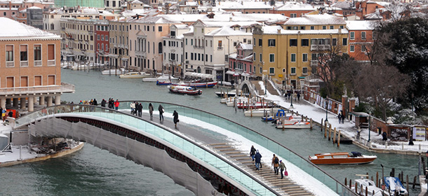 People walk on the Calatrava bridge under the snow during an "acqua alta" on December 19, 2009 in Venice. The "acqua alta" (high water), a convergence of high tides and a strong sirocco, stood at 114 centimeters in the morning while snow was falling on the northern Italian town. AFP PHOTO / Marco Sabadin (Photo credit should read Marco Sabadin/AFP/Getty Images)