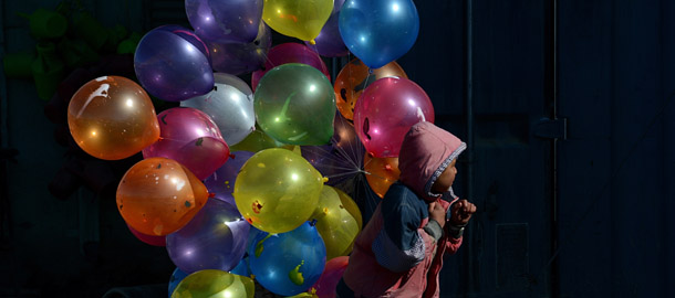 An Afghan boy walks with balloons for sale on a cold winter's day in Kabul on February 7 , 2013. Despite massive injections of foreign aid since the fall of the Taliban in 2001, Afghanistan remains desperately poor with the lowest standards in the world. AFP PHOTO/ SHAH Marai (Photo credit should read SHAH MARAI/AFP/Getty Images)