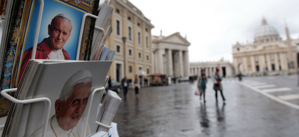 Postcards of Pope Benedict XVI, bottom, and late Pope John Paul II, are displayed outside a kiosk with St. Peter's Basilica in the background, at the Vatican, Monday, Feb. 11, 2013. Pope Benedict XVI announced Monday that he would resign Feb. 28 Ã³ the first pontiff to do so in nearly 600 years. The decision sets the stage for a conclave to elect a new pope before the end of March. (AP Photo/Gregorio Borgia)