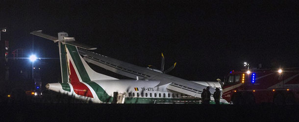 Firefighters are seen next to a an ATR 72 airliner of Romanian carrier Carpatair that ended up off the runway upon landing at Rome's International Leonardo Da Vinci airport, in Fiumicino, outskirts of Rome, Saturday, Feb. 2, 2013. Vitaliano Turra, an official of Italy's civil aviation authority ENAC, told Sky TG24 TV that the flight attendant aboard the airliner and one of the passengers were hospitalized. The Italian news agency ANSA said injuries consisted of fractures or bruises, and that none was life-threatening. (AP Photo/Angelo Carconi)
