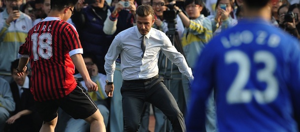 Football superstar David Beckham (C) plays football with students during a visit to a middle school in Beijing on March 20, 2013. Beckham flew to Beijing on March 20 to take up a role as ambassador for the Chinese Super League, with domestic media saying he will visit three cities on a five day trip. AFP PHOTO /WANG ZHAO (Photo credit should read WANG ZHAO/AFP/Getty Images)