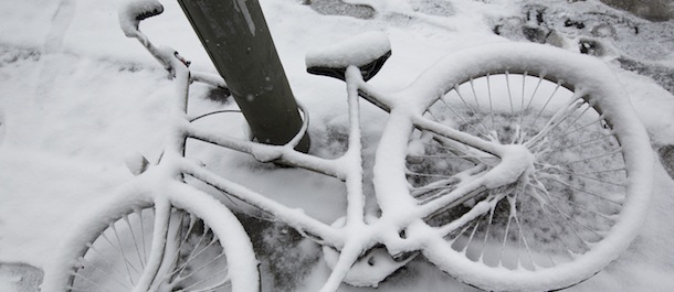 Fresh snow covers a bicycle on he ground in Berlin, Germany, Tuesday, March 19, 2013. (AP Photo/Gero Breloer)